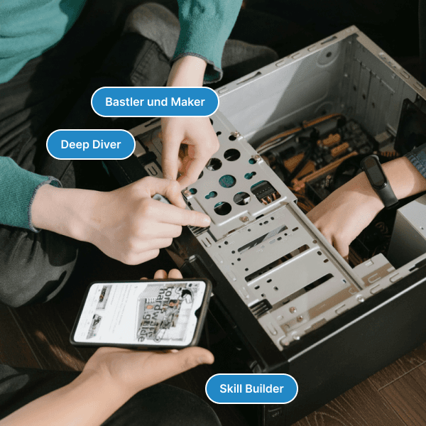 Zwei Personen bauen einen Computer zusammen, daneben ein Smartphone mit Anleitung; darueber die Etiketten „Bastler und Maker“, „Deep Diver“ und „Skill Builder“