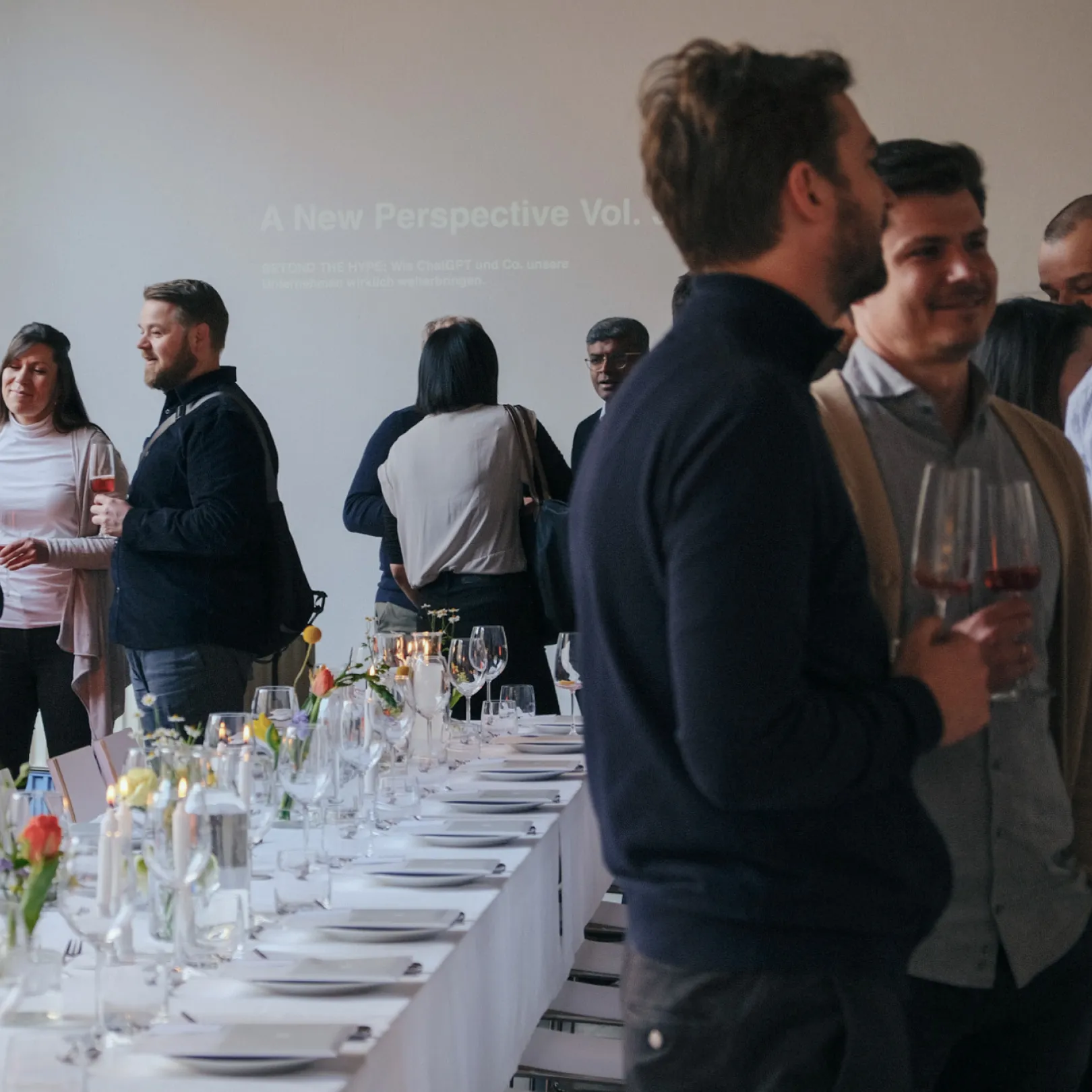 Event photo from the A New Perspective dinner series with a discussion round and a festively laid table.