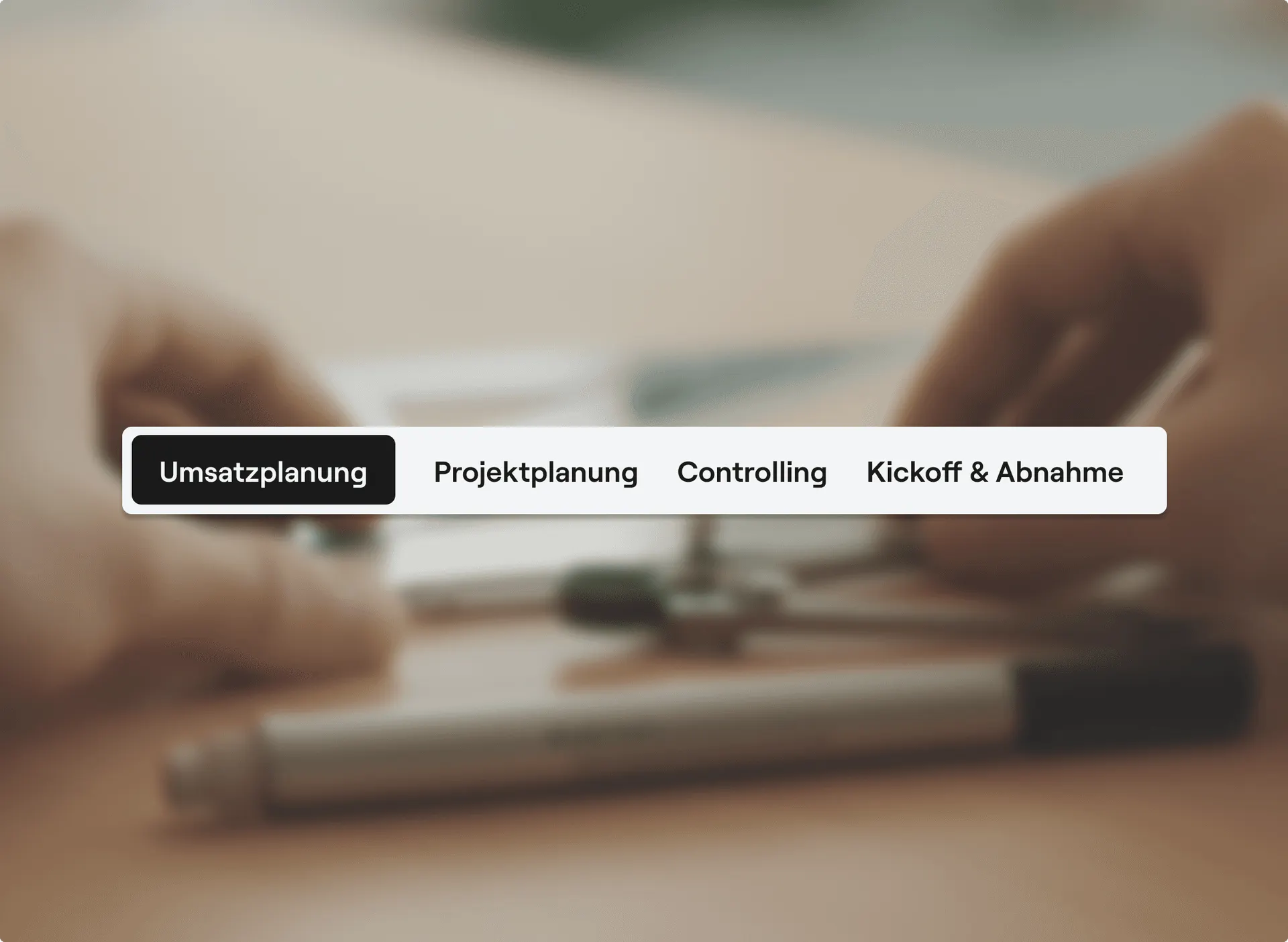 Toggle bar with the sections revenue planning, project planning, controlling and kickoff & acceptance in front of a blurred desk