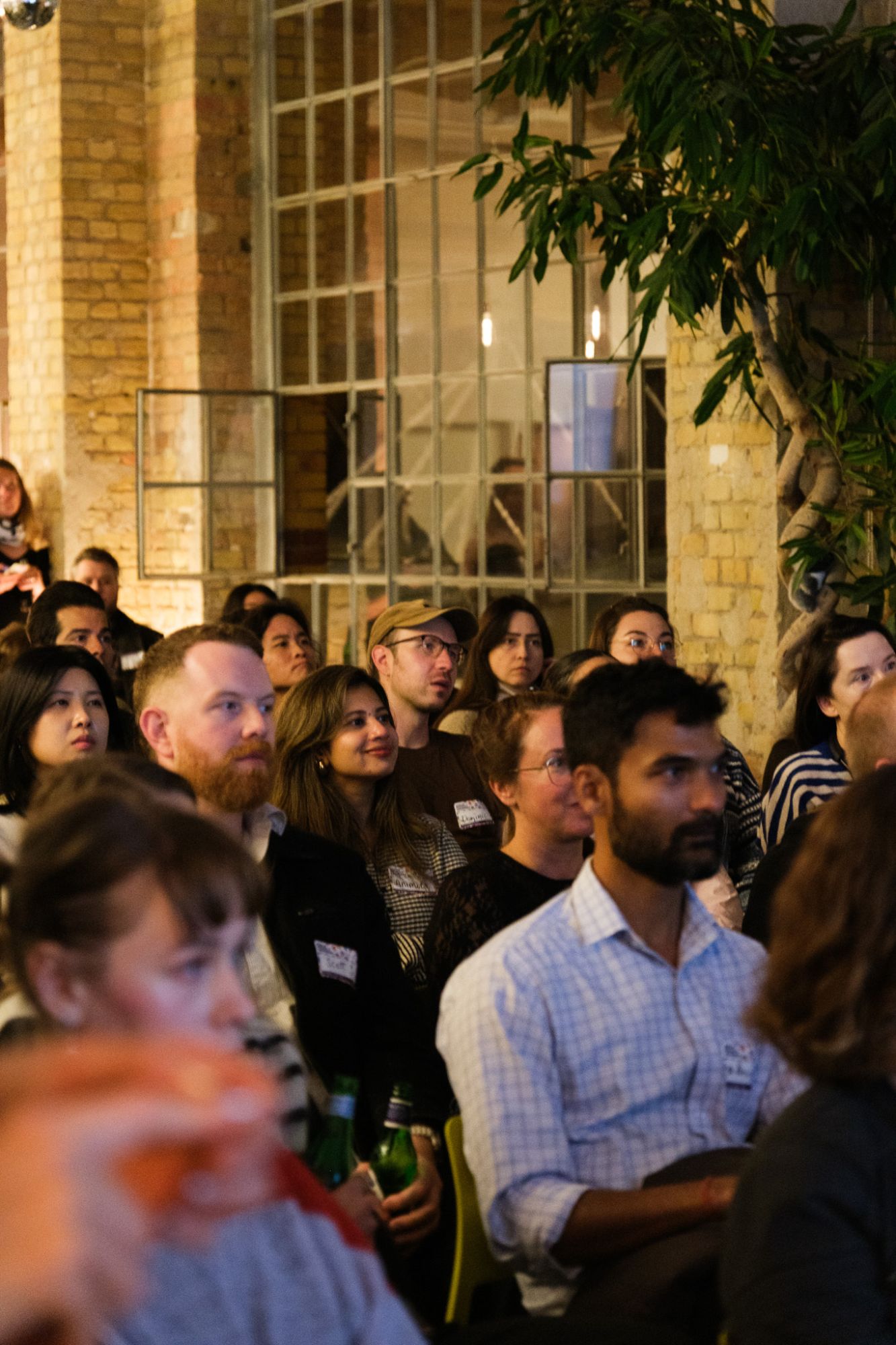 Gäste des Meetups verfolgen den Vortrag vor den Industriefenstern des Studios